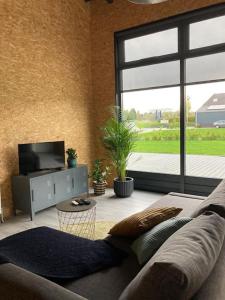 a living room with a couch and a large window at loods 14-2 in Groningen