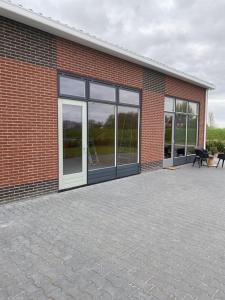ein Backsteingebäude mit Glasfenstern und einer Terrasse in der Unterkunft loods 14-2 in Groningen