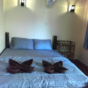 ein Bett mit zwei Blumen darüber in der Unterkunft Captain Chim's Guest House in Kep