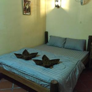 a bed with two pillows on top of it at Captain Chim's Guest House in Kep