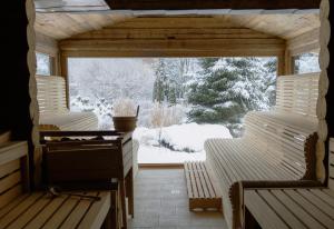 a screened in porch with two benches in the snow at Alpejski Boutique Hotel in Karpacz