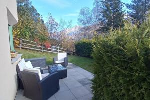 a patio with two chairs and a table at Studio Röven in Scuol