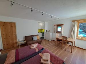 a living room with a bed and a dining room at Studio Röven in Scuol