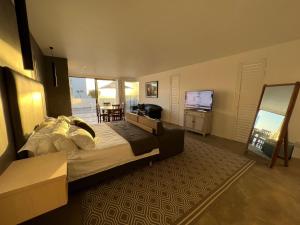 1 dormitorio con 1 cama grande y TV en Flip Flops Villa, en Yzerfontein