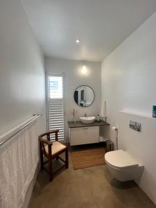 a bathroom with a toilet and a sink and a mirror at Flip Flops Villa in Yzerfontein