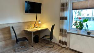 a room with a desk and chairs and a window at Pension zum Winterberg in Elsterwerda