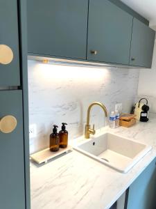 a kitchen counter with a sink and blue cabinets at MONACO # MENTON - 4 PERSONS - PRIVATE PARKING - FULL RENOVATED - CLIM - CARRE OR - Beach & Sun in Menton