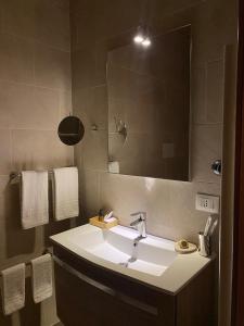 La salle de bains est pourvue d'un lavabo, d'un miroir et de serviettes. dans l'établissement Maison Des Fleurs, à Naples