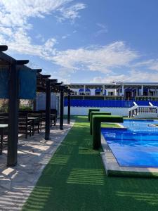 Al-Ashkhara Beach Resort منتجع شاطئ الأشخرة في الشرقية: منتجع فيه مسبح وطاولات ومبنى