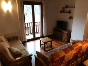 a living room with a couch and a tv at Apartament Dúplex de Can Bota Avet-p in Setcases