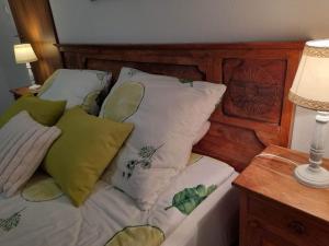 a bed with pillows on it with a wooden head board at Nad Strumykiem in Mszana Dolna