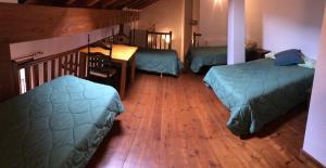um quarto com 2 camas e piso em madeira em Apartament Dúplex de Can Bota Avet-p em Setcases