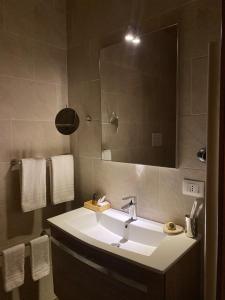 La salle de bains est pourvue d'un lavabo et d'un miroir. dans l'établissement Maison Des Fleurs, à Naples