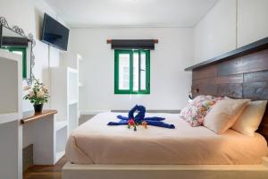 una cama con un animal de peluche azul sentado en ella en Hermosa Casa vacacional, muy cerca a la playa. en Guatiza