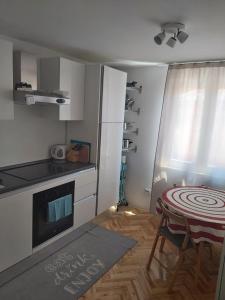 a small kitchen with a table and a dining room at Beach House Valerija in Rovanjska