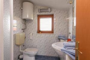 a bathroom with a toilet and a sink at Villa Marcelina in Seget Vranjica