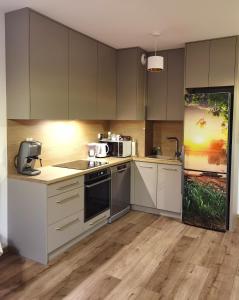 a kitchen with white cabinets and a microwave at Apartament Olecko Centrum in Olecko