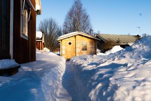 un cortile coperto da neve accanto a una casa con un edificio di Luleå Village Cabin a Luleå