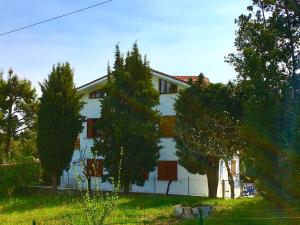 ein weißes Haus mit Bäumen davor in der Unterkunft Mansarda seaview in Senigallia