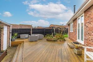 a patio with two white chairs on a wooden deck at Host & Stay - Gorse Cottage in Mundesley