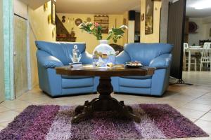 un salon avec un canapé bleu et une table avec un vase dans l'établissement Sa Domu Frisca, à Domusnovas
