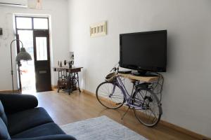 een fiets geparkeerd in een woonkamer met een flatscreen-tv bij Casa Gil Vicente in Évora