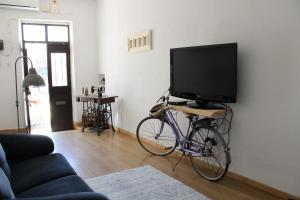 a bike parked in a living room with a flat screen tv at Casa Gil Vicente in Évora