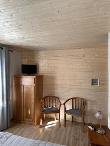 a bedroom with two chairs and a tv on a wall at Quinta do Chao D'Ordem in Vila Nova de Foz Coa