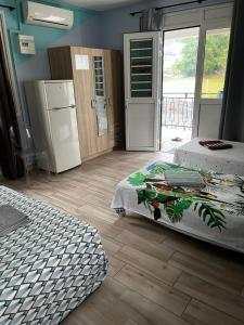 a bedroom with two beds and a door to a patio at L'Escale du Mouillage in Saint-Pierre