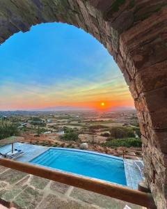 basen w kamiennej ścianie z zachodem słońca w obiekcie Villa Papa w mieście Glinádhon