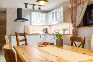 una cucina con tavolo in legno e una sala da pranzo di Domek w Górach - Przy Potoku a Zakopane