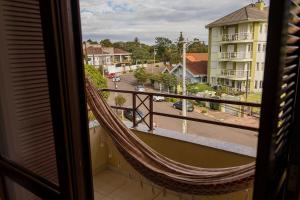 eine Hängematte auf einem Balkon mit Stadtblick in der Unterkunft Condomínio Familiar - Aptos Novos e Completos in Nova Petrópolis