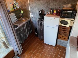 a small kitchen with a white refrigerator and a sink at Gite du mas de Sarrot in Mars