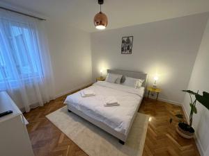 a bedroom with a white bed with two towels on it at ESI Apartments #Central in Timişoara