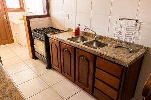 a kitchen with a sink and a stove at Condomínio Familiar - Aptos Novos e Completos in Nova Petrópolis +159 photos