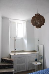 a bedroom with a bed and a window and a chandelier at Casa da Freiria in Évora