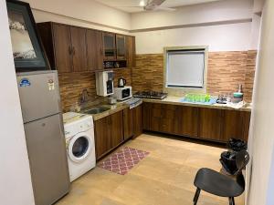 a kitchen with a refrigerator and a washer and dryer at Boloors sea la vie in Suratakal