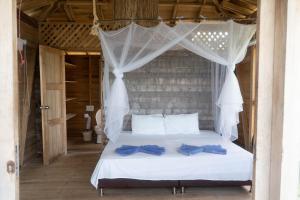 1 dormitorio con 1 cama blanca con arcos azules en CasaCoral Hotel, en Puerto Limón
