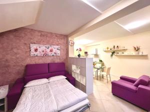 a bedroom with a purple bed and a table at Limone DownTown in Limone sul Garda