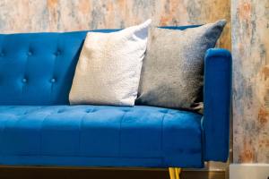 - un canapé bleu avec deux oreillers dans l'établissement COSY Birmingham City Centre Spacious Apartment-Free parking, WiFi, Contractors, HS2, Bullring, Birmingham City FC, à Birmingham