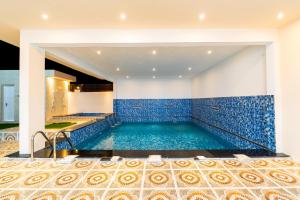 una piscina en una casa con azulejos azules en COMFORT CHALET & APARTMENTS en Al Ḩadd