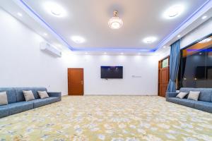 a large room with two couches and a flat screen tv at COMFORT CHALET & APARTMENTS in Al Ḩadd