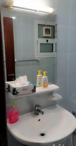 een badkamer met een witte wastafel en een spiegel bij Lemas 1001 in Ajman 