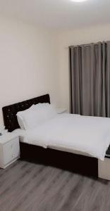 a bedroom with a large bed with a black headboard at Lemas 1001 in Ajman 