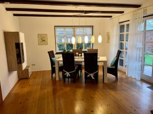 uma sala de jantar com mesa e cadeiras em Ferienhaus Blaue Nordseewelle em Esens