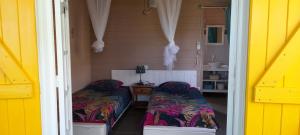 a small room with two beds in a house at Gwadakaz in Sainte-Rose