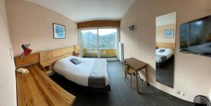 a bedroom with two beds and a large window at Logis De La Grande Cascade in Le Tholy