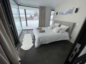a bedroom with a white bed and a large window at Le Nordic in Grande Riviere