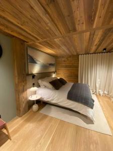 1 dormitorio con 1 cama grande y techo de madera en CHALET UTOPIA, en Saint-Gervais-les-Bains