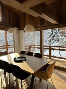 ein Esszimmer mit einem Holztisch und Stühlen in der Unterkunft CHALET UTOPIA in Saint-Gervais-les-Bains